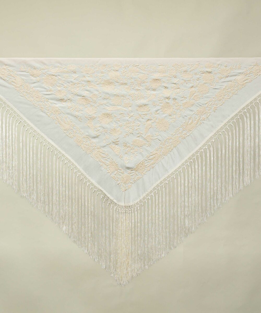 El mantoncillo Seguiriya crudo es perfecto para cualquier look flamenco 2024. Un mantoncillo crudo bordado en seda del mismo color y fleco largo.