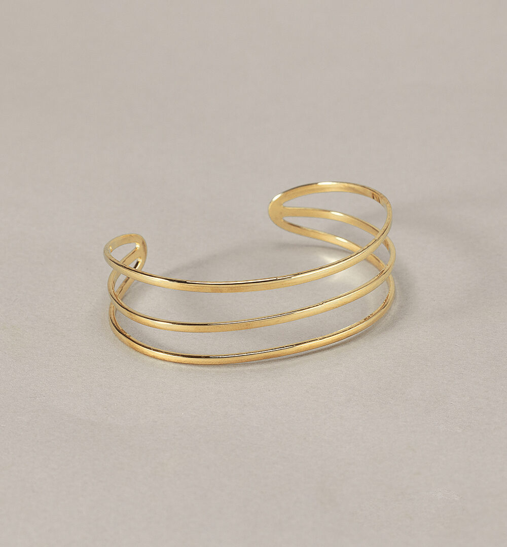 El Brazalete Triple destaca por su diseño minimalista y moderno. Esta pulsera rígida es la definición perfecta de elegancia y sencillez.