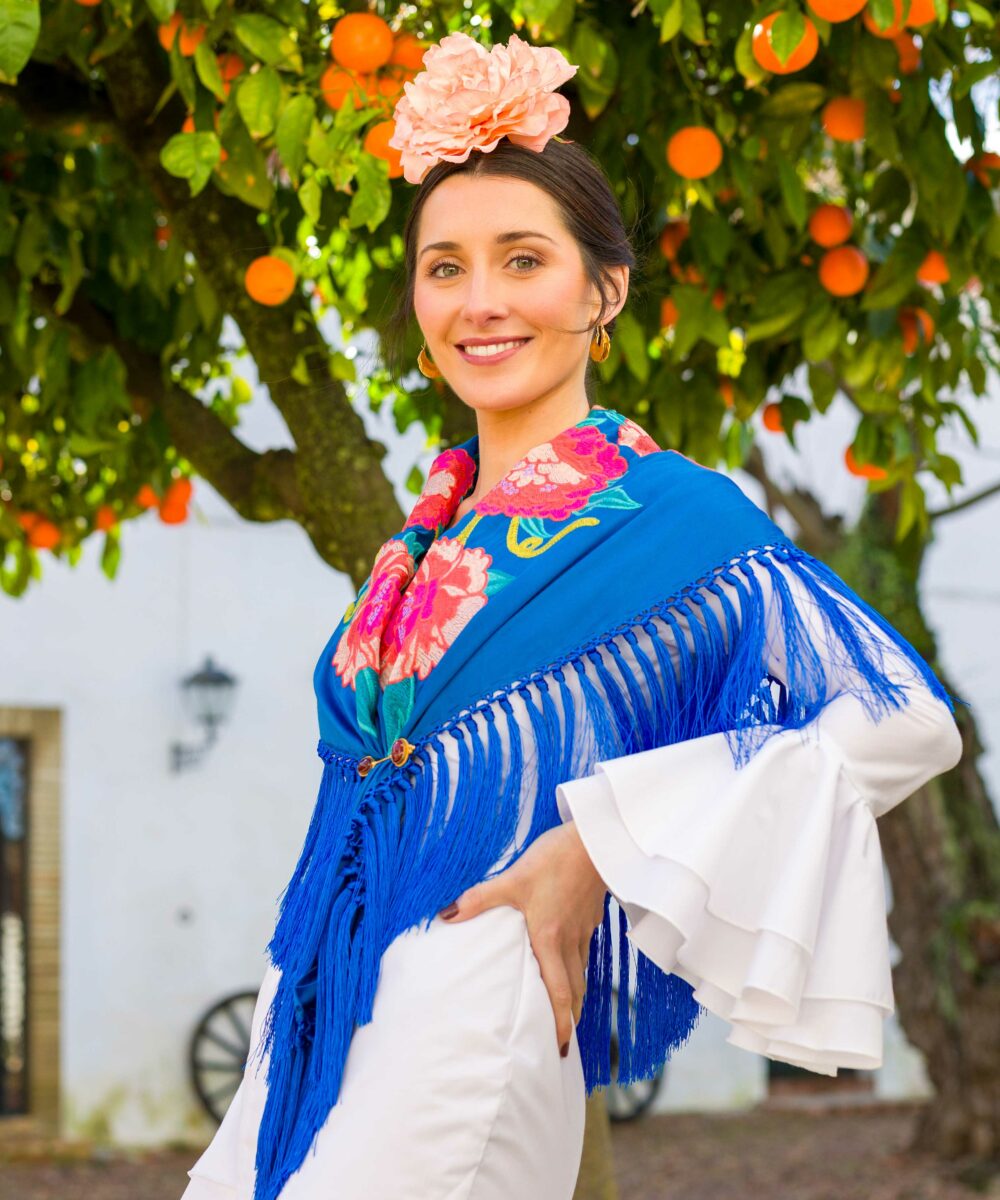 El mantoncillo Carmen DW azul klein es perfecto para cualquier look flamenco 2025. Un mantoncillo azul bordado en seda con colores y fleco de borlón.